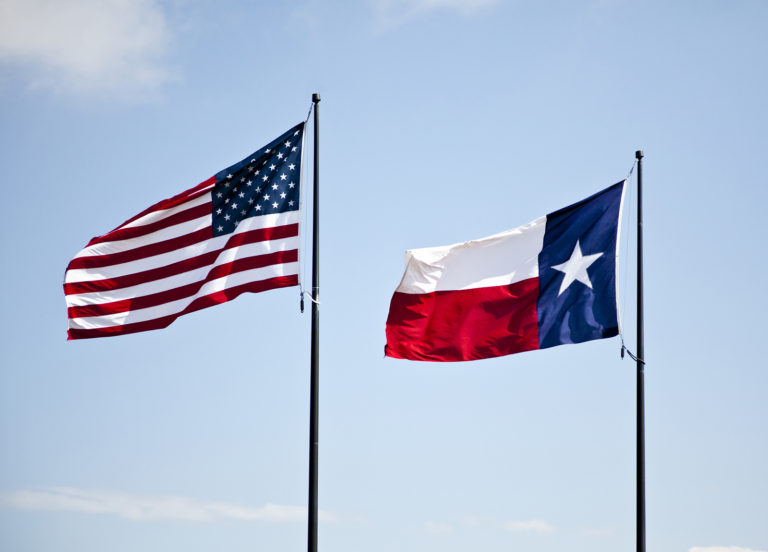 The American And Texas Flags Flying High Together Against A Blue - Dr 